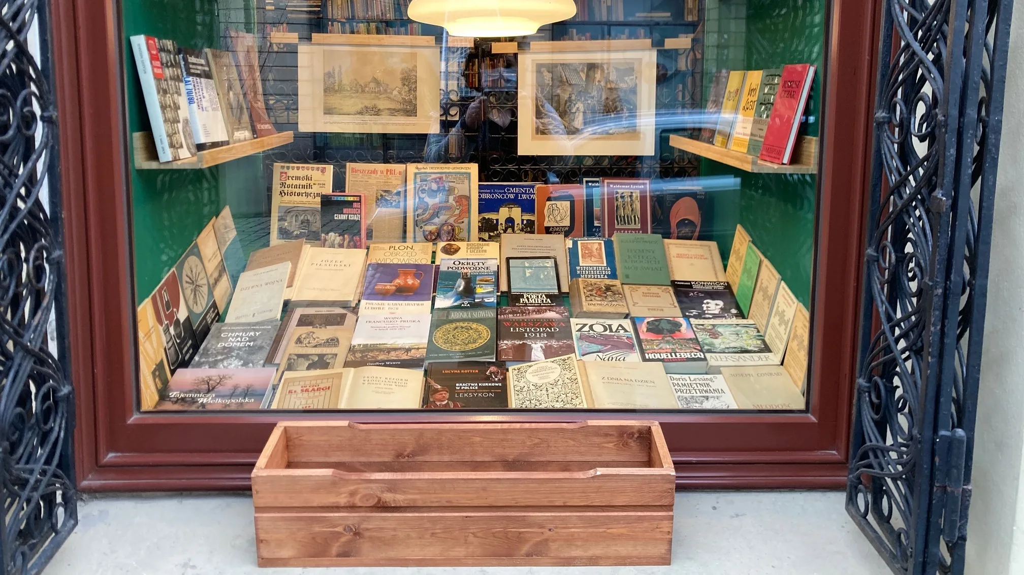 Boîte à livres devant la vitrine de l’Antykwariat J.K. Żupański à Poznań