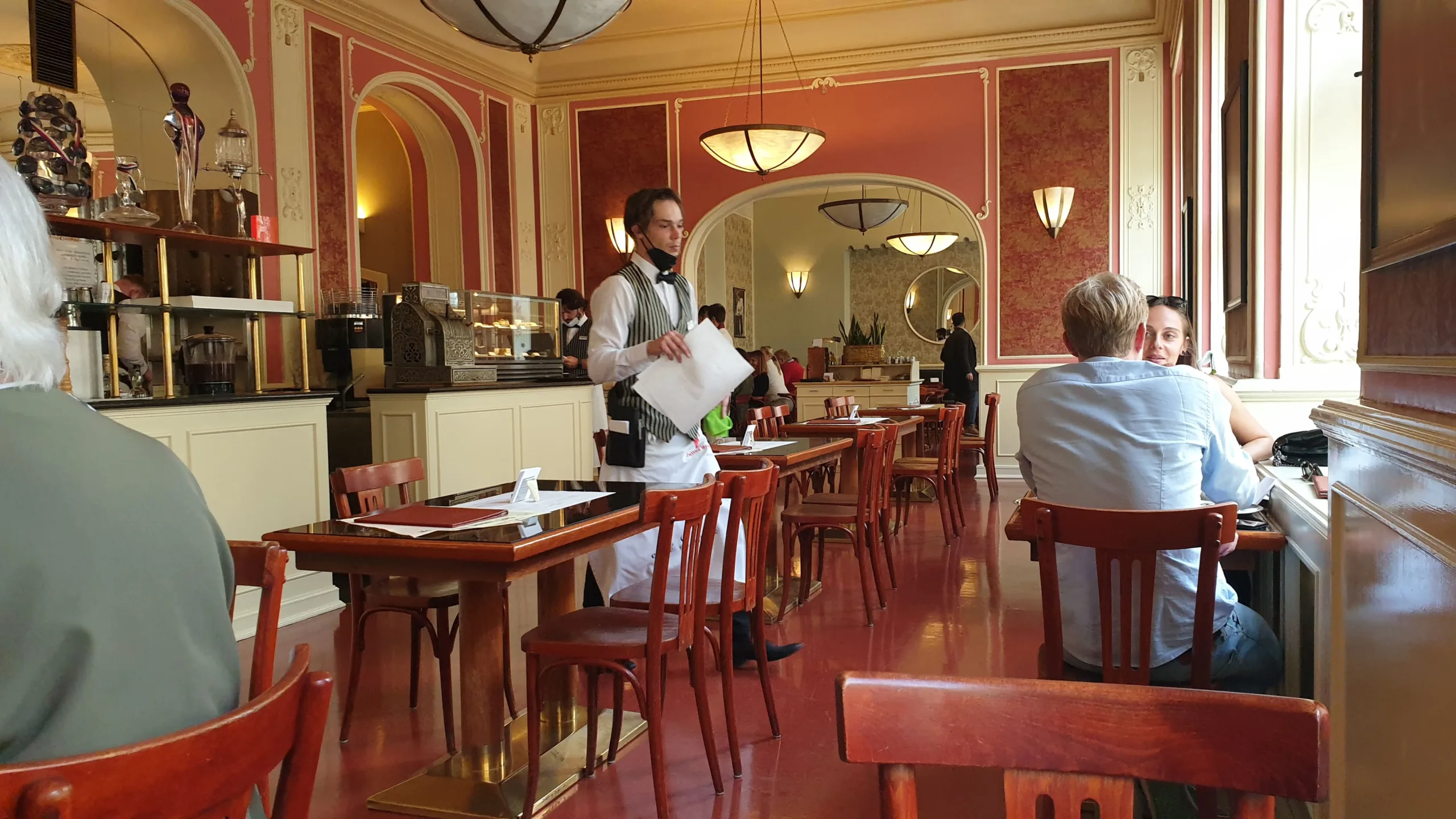 Serveuse en tenue traditionnelle dans la salle du Café Louvre à Prague