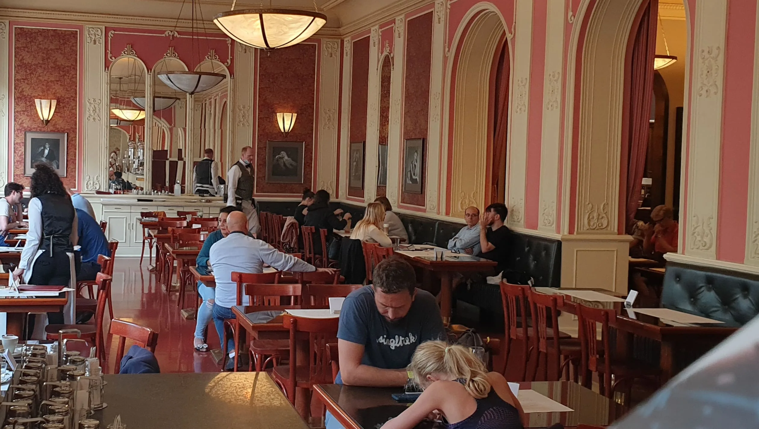 Salle du Café Louvre à Prague avec ses boiseries, miroirs et tables