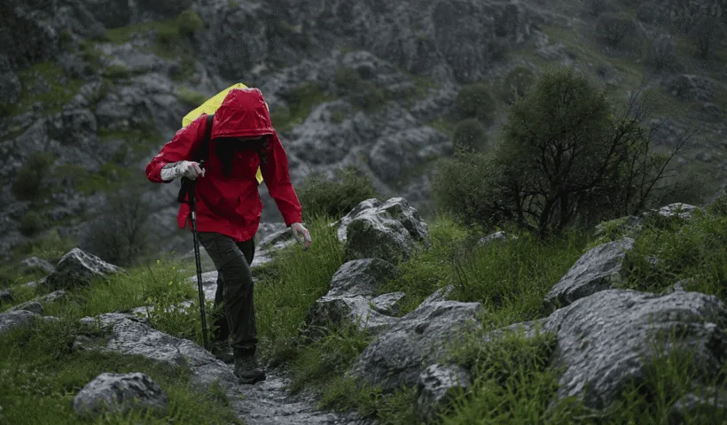 Randonneuse marchant sous la pluie sur un sentier de montagne