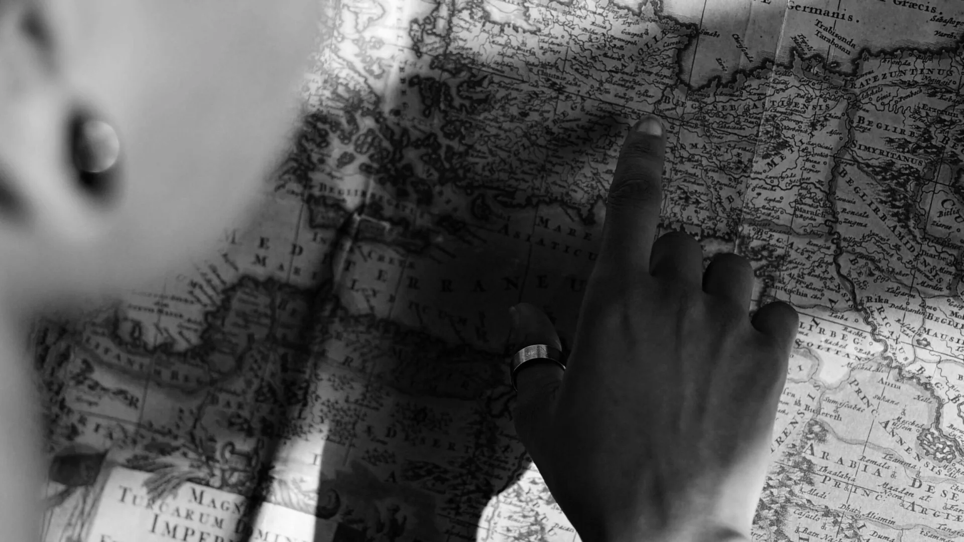 Main cherchant une destination sur une carte ancienne