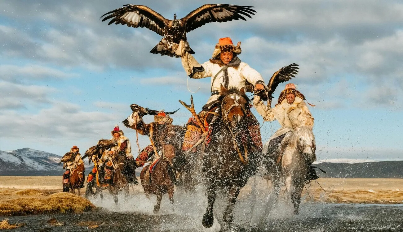 Chasseurs kazakhs à cheval avec leurs aigles royaux dans les steppes de Mongolie occidentale.