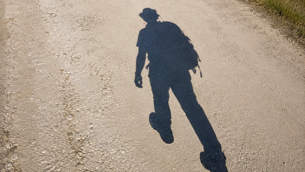 Ombre d'un randonneur marchant sur un sentier de la Rota Vicentina, dans le sud du Portugal.