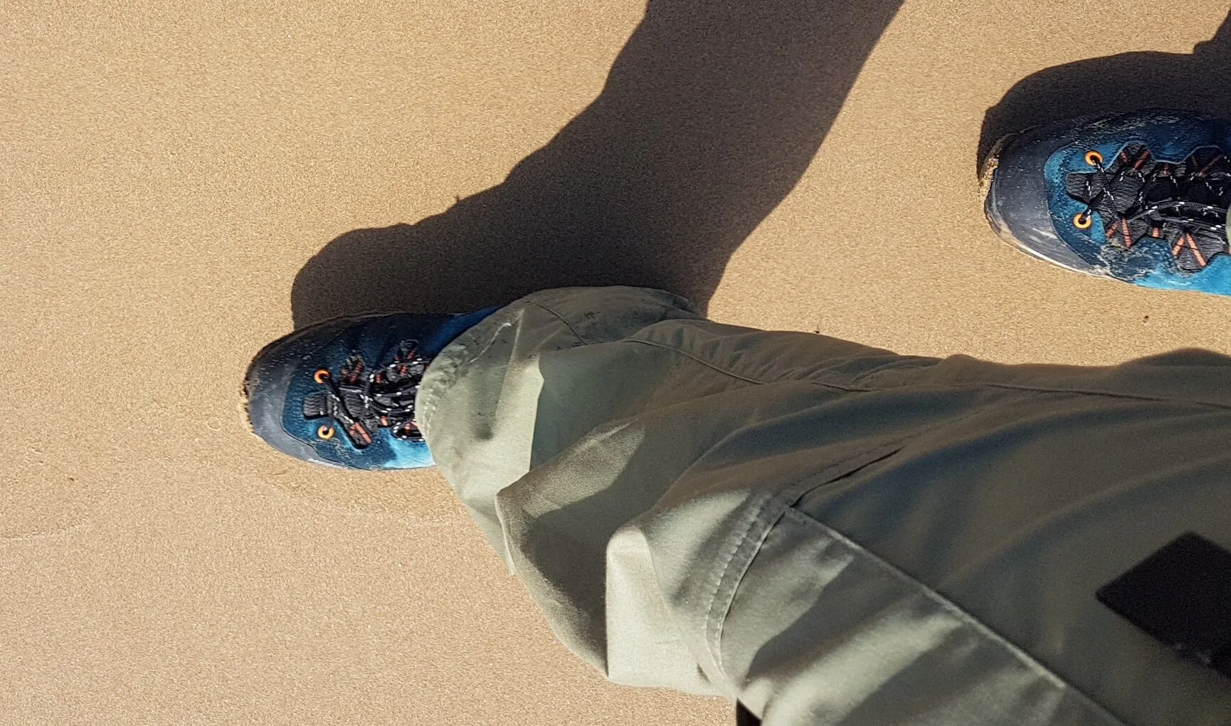 Chaussures de randonnée couvertes de sable après une étape de marche