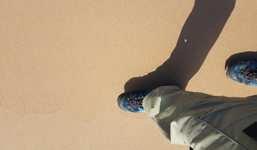 Chaussures de randonnée couvertes de sable après une étape de marche