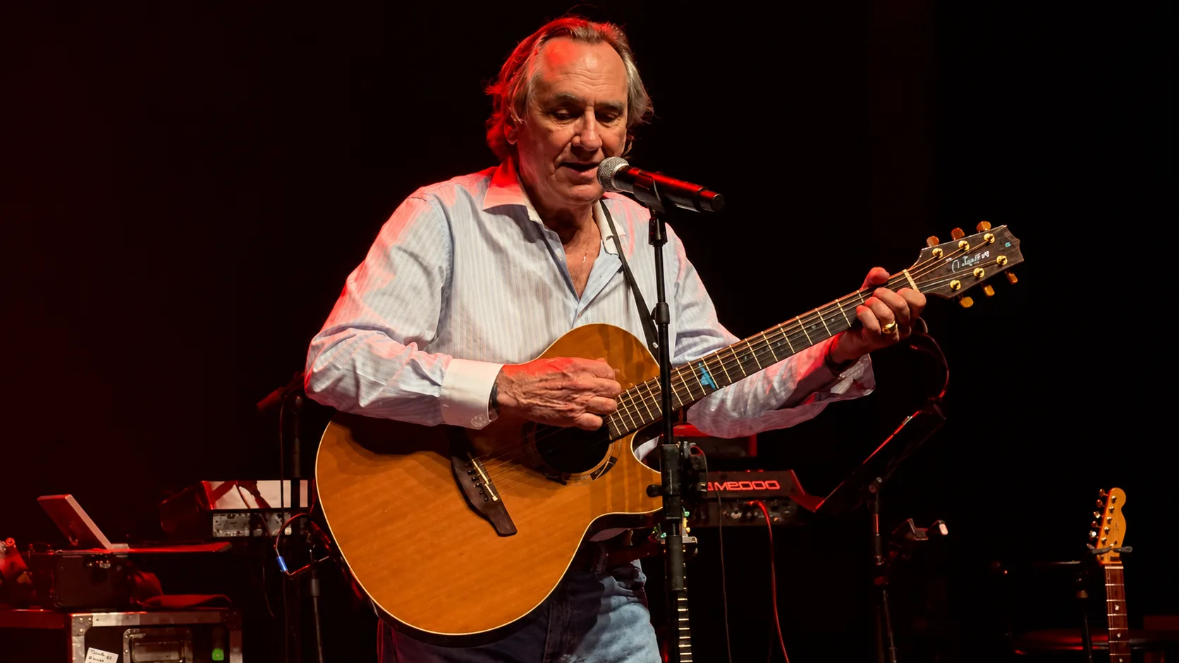 Philippe Lavil chante et joue de la guitare sur scène à Paris