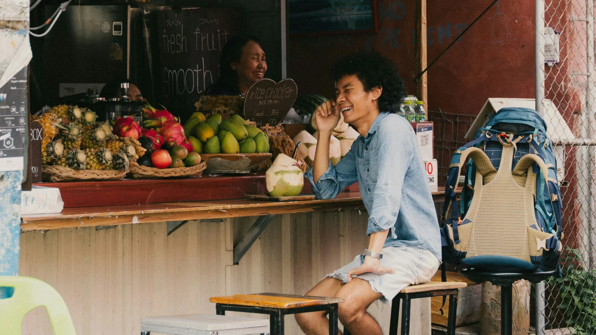 Un voyageur échange avec une vendeuse à un stand de fruits à Chiang Mai