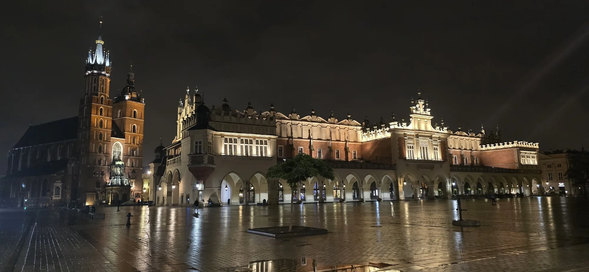 le Rynek Główny à Cracovie illuminé de nuit avec la basilique Sainte-Marie et la Halle aux Draps.