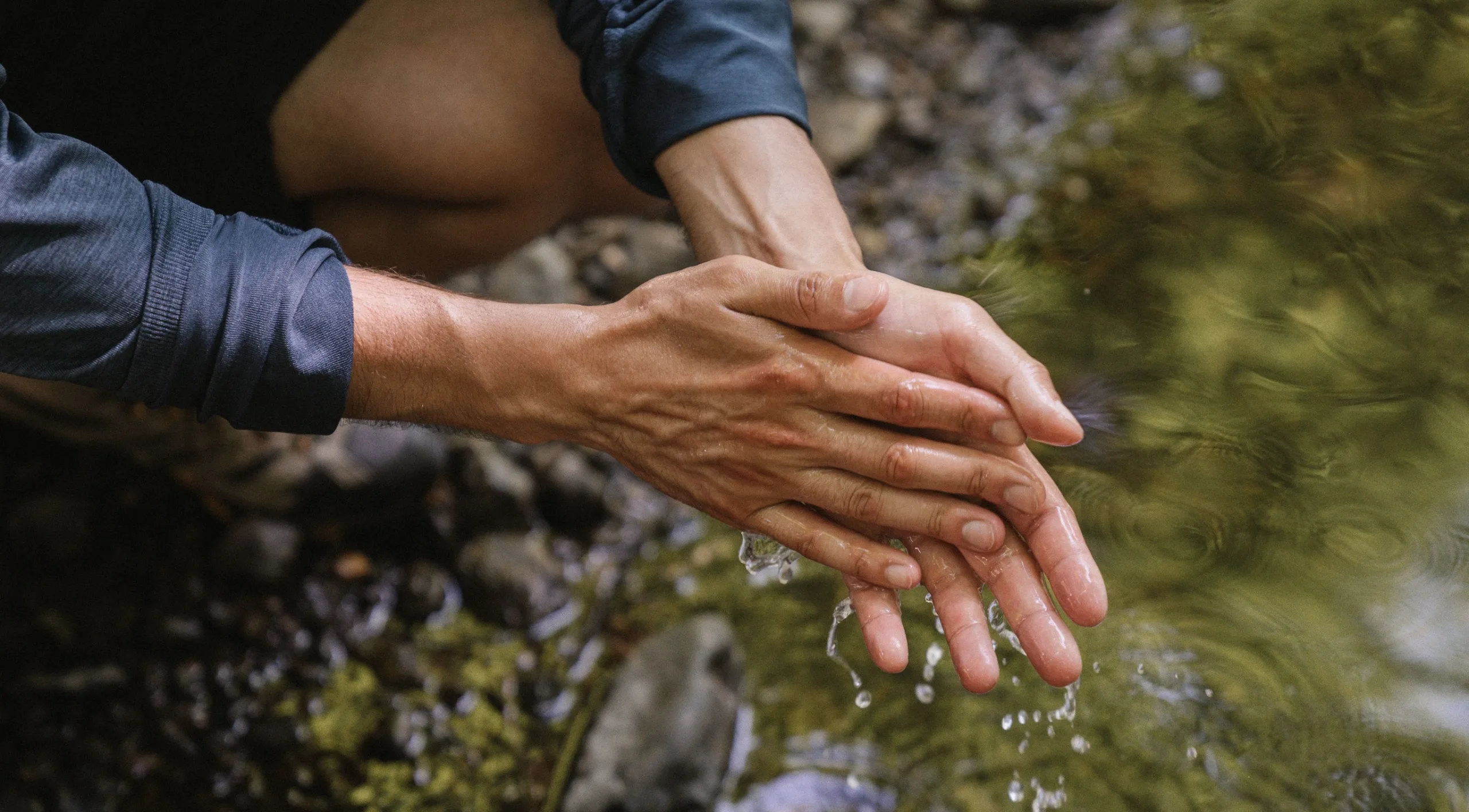 Se laver les mains dans la rivière, à l'eau claire.