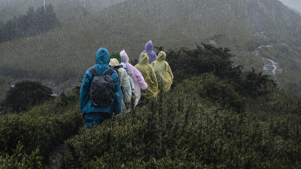 Groupe de randonneurs marchant sous une forte pluie en montagne